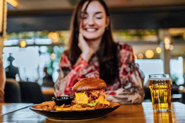 istock Smiling woman looking at burger at a restaurant 1468927166