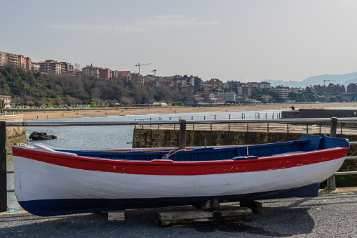 White boat and behind the municipality of Getxo and the beach of Ereaga