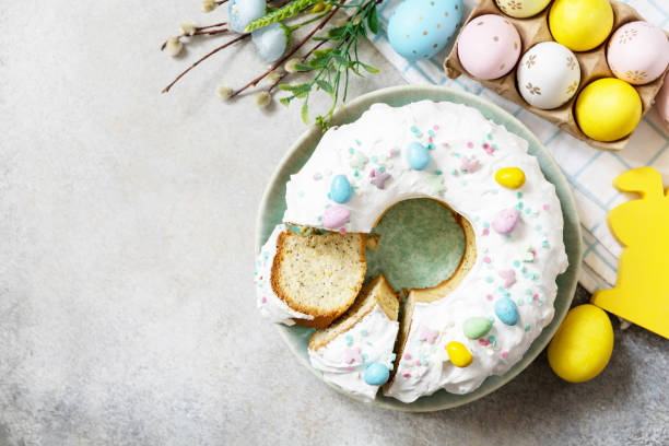 istock Happy Easter holidays, tasty dessert. Glazed easter lemon cake decorated with confectionery and mini chocolate eggs candy on gray stone background. View from above. Copy space. 1468931775