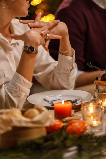 istock Young woman gesturing while sharing an interesting story with friends during a Christmas dinner party 1468932001