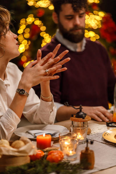 istock Young woman gesturing while sharing an interesting story with friends during a Christmas dinner party 1468932004