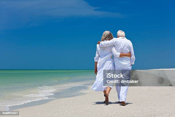 Rear View Of Senior Couple Walking On Beach Stock Photo - Download Image Now - Senior Adult, Beach, Aging Process