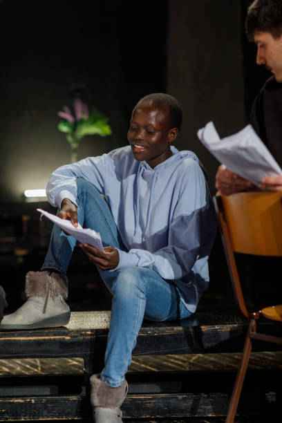 istock Beautiful Young Actress Rehearsing With Scripts On Stage In Theatre 1468933667