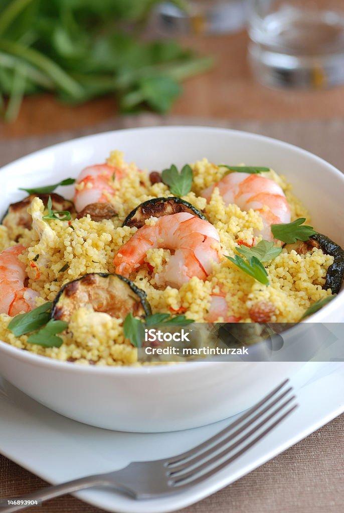 Couscous with prawns and courgette Bowl with couscous, tiger prawns and courgette Cilantro Stock Photo