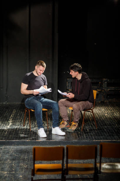 istock Two Young Actors Rehearsing With Scripts On Stage In Theatre 1468941021