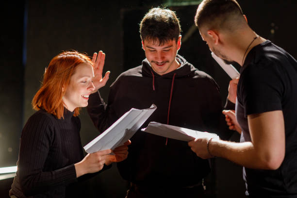 Actors Rehearsing With Scripts On Stage In Theatre Actors rehearsing with scripts on stage in theater. acting class stock pictures, royalty-free photos & images