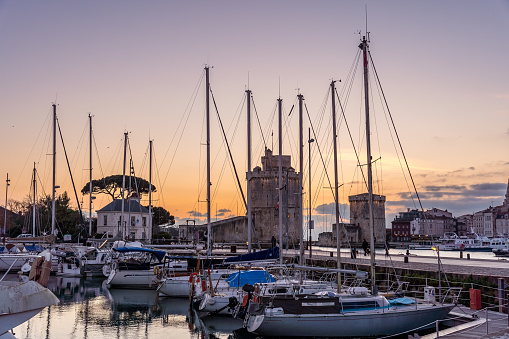 La rochelle harbor at sunset. the famous towers of La Rochelle are illuminated with christmas light. many boats on first ground