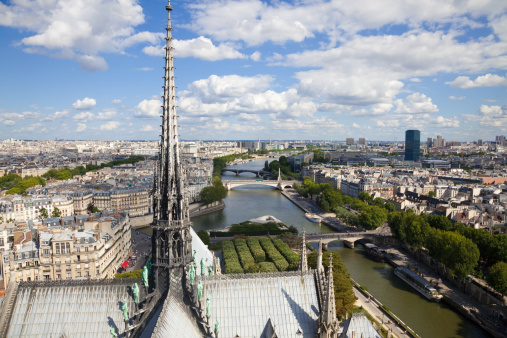 Famous Spire with copper statues of the twelve apostles, overlooking the skyline of Paris at a summer day.