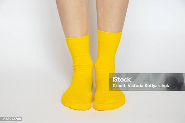 Womens Legs In Yellow Socks On A White Background Stock Photo - Download Image Now - Sock, Foot, White Color