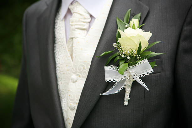 White rose boutonniere on groom's suit stock photo