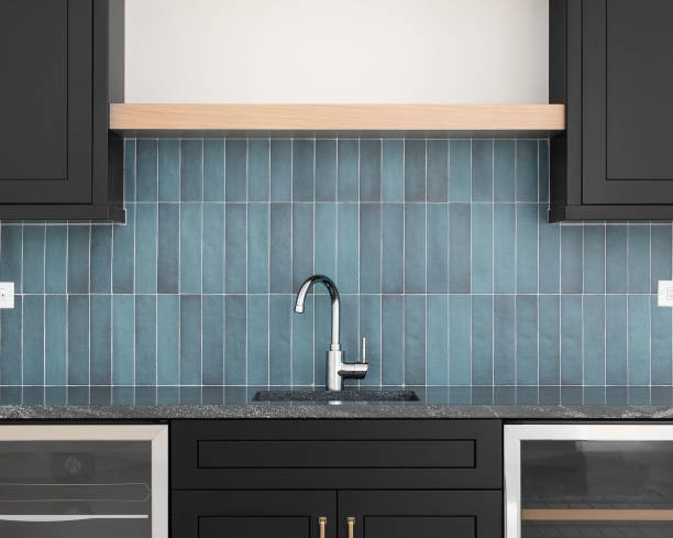 istock A faucet detail with black cabinets and a blue tile backsplash. 1468944312