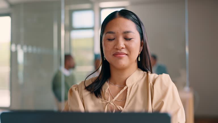 Asian business woman, laptop and breathing in for relief, relaxation or stress management at the office. Happy, calm and relaxed female employee working on computer taking a deep breath at workplace