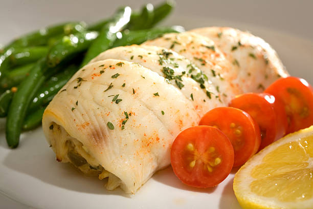 Crab Stuffed Flounder and Tomatoes Gourmet dinner of crab stuffed flounder with cherry tomatoes and green beans. stuffed stock pictures, royalty-free photos & images