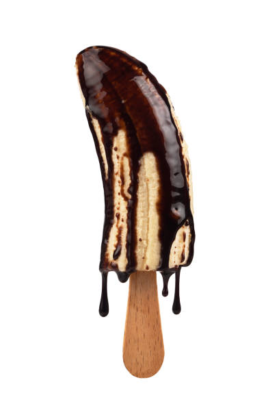 Banana ice cream is poured with liquid chocolate, isolated on a white background