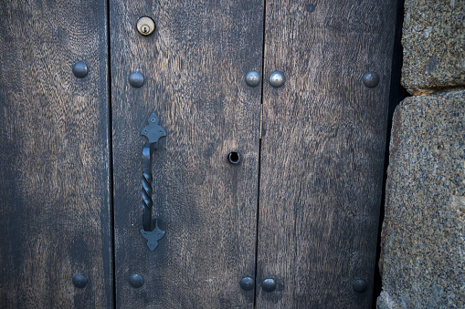 An old medieval keyhole on a gold / brass door with a rutsy ornate plate.