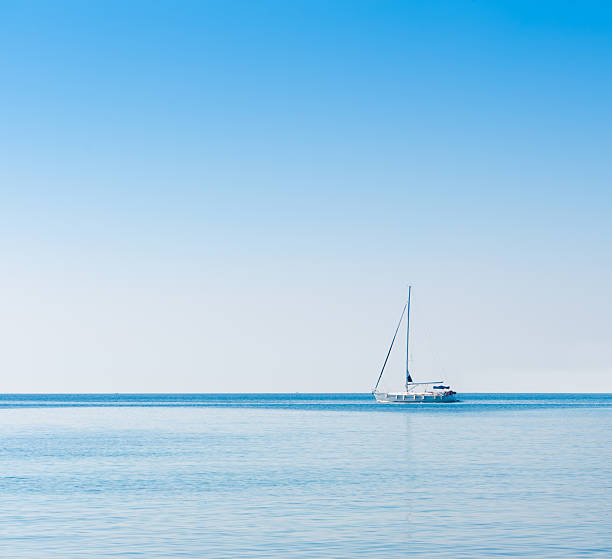 Sailboat in Adriatic sea. Blue sky over water horizon. Copyspace. stock photo