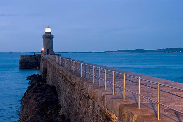 Guernsey Lighthouse at night Lighthouse and Breakwater in Guernsey at night groyne stock pictures, royalty-free photos & images