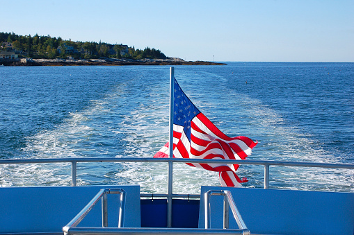 Classic ferry leaving a Maine island... American flag flying in the wind.