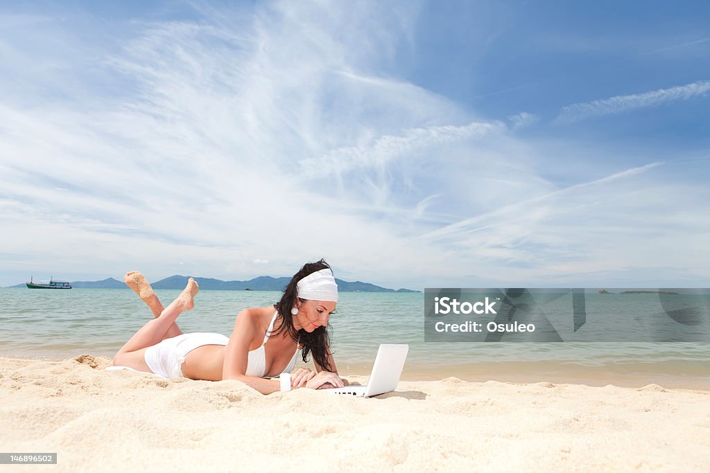Милая женщина с белый ноутбук на пляже летом - Стоковые фото Белый роялти-фри
