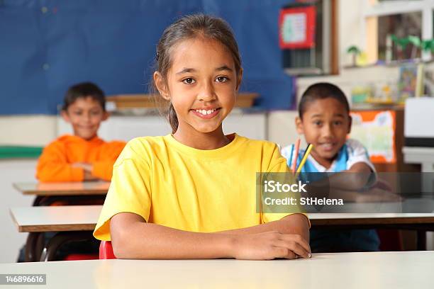 Tres Niños En La Escuela Primaria De Estar Escritorios En Su Clase Foto de stock y más banco de imágenes de Afrodescendiente