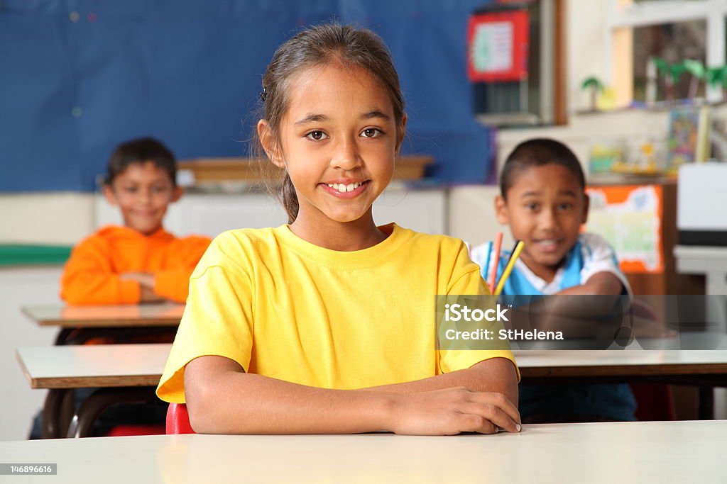 Trzy szkoły podstawowej dzieci siedzi na biurko w klasie - Zbiór zdjęć royalty-free (Afrykanin)