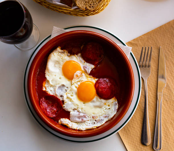 istock Cuisine of Spain, fried eggs with chorizo sausages and tomato paste served on plate 1468968733
