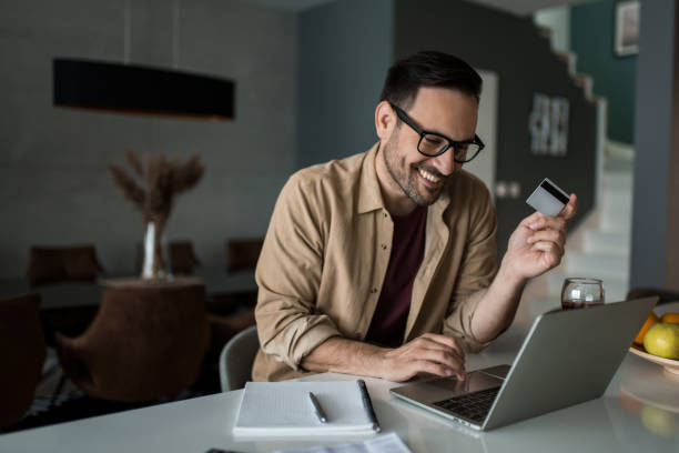 istock Happy young man using online banking on his laptop at home. 1468970578