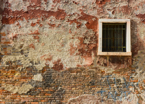 istock White window on old house wall Cracks in concrete visible red bricks. 1468970591