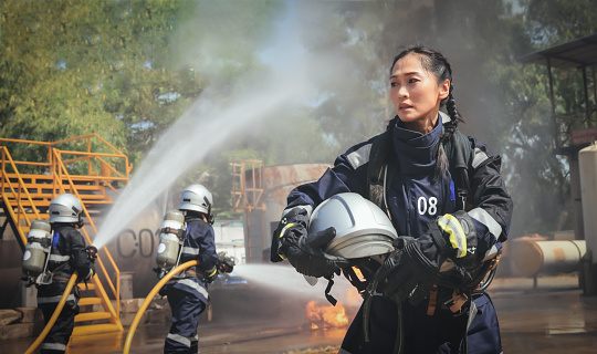 Portrait female Firefighters Extinguishing hard working  at   accident site, International woman days , Professional female Firefighter hold helmet walk back to break after job done