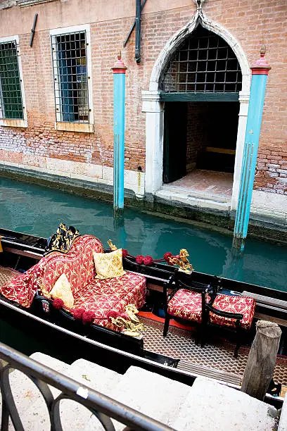 venice,gondola with sofa with palace entrace  faced on canal