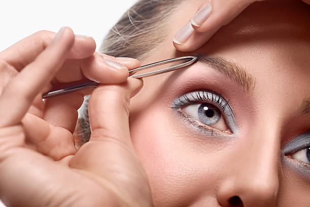 istock Woman tweezing eyebrow 146899019