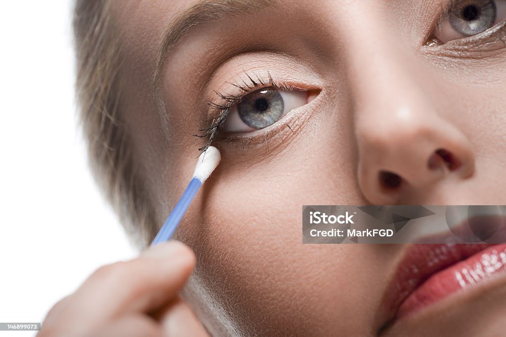 Removing make-up with cotton bud Close-up of woman removing make-up using a cotton bud Cotton Swab Stock Photo