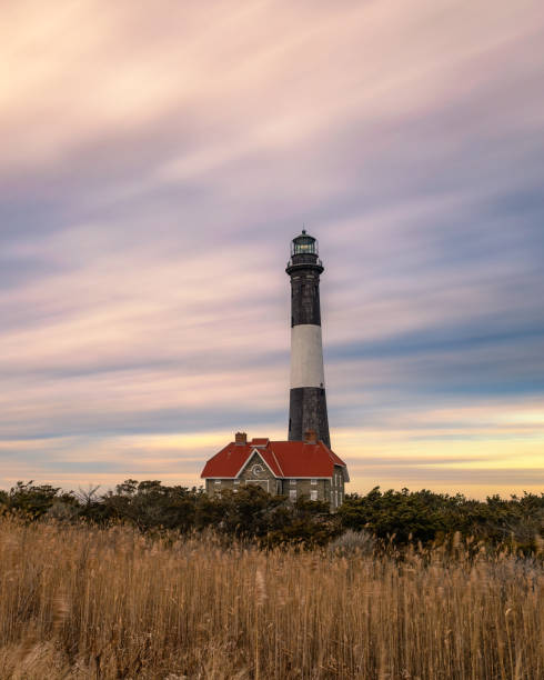 istock Streaky wispy colorful sunset clouds behind a stone lighthouse 1468997178