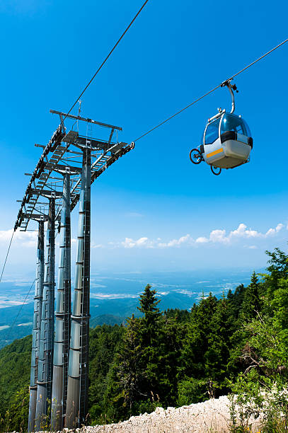 Mountain bike on cable car elevator over alpine forest. stock photo