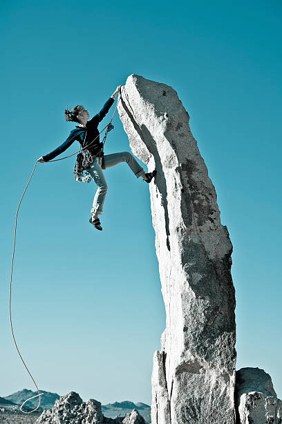 istock Woman climbing a rock and reaching the summit 146899840