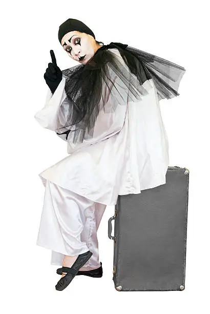 sitting black and white pierrot showing finger on grey suitcase overwhite