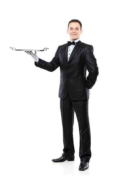 A young man in a tuxedo with a serving tray Young person in a suit holding an empty tray isolated on white background formal glove stock pictures, royalty-free photos & images