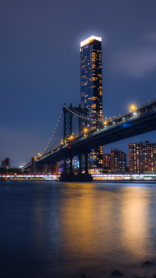 Night view of Brooklyn Bridge. with long exposure shot. Producing smooth water effect.