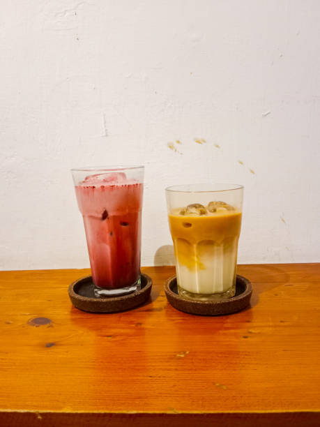 un verre de machiatto au caramel et un latte en velours rouge sur la table en bois - latte machiatto photos et images de collection
