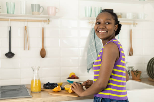 istock Happy African young woman making fruit juice at her kitchen 1469001397