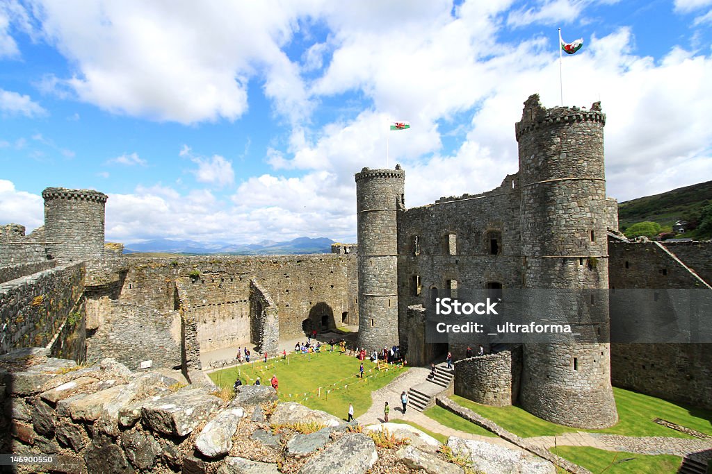 Ruins of Harlech Castle with Mount Snowdon in background Ultra-wide angle view of the inner ward with large round towers at each corners. Harlech Castle, Gwynedd, Wales. Snowdonia Stock Photo