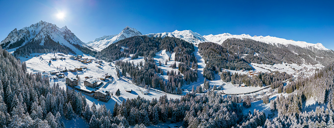 Aerial view of a winter landscape with snowcapped mountains and ski slopes in the ski-resort Gargellen. Panorama of the valley.