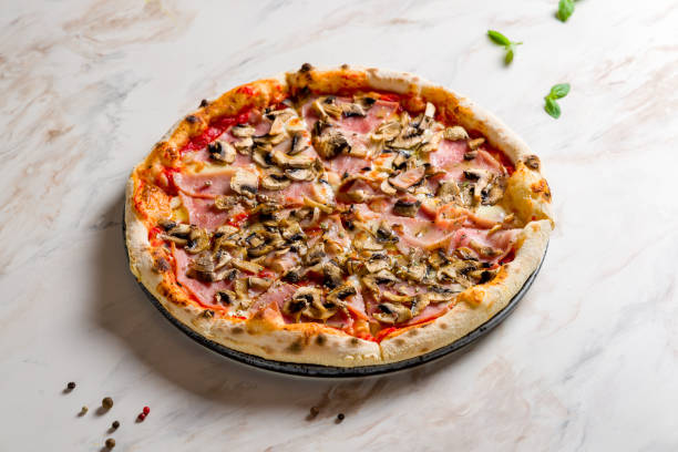 istock Pizza with ham and mushrooms with tomato sauce on white marble table 1469013742