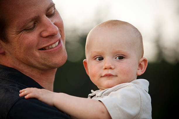 istock Smiling Father Holding Baby 146901459