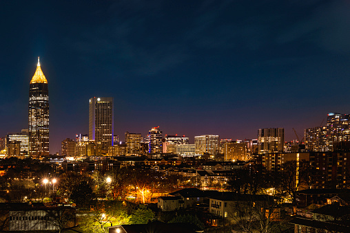 Atlanta City Skyline at Night with Skyscrapers and Buildings at Cloudy Twilight over the Trees in Georgia