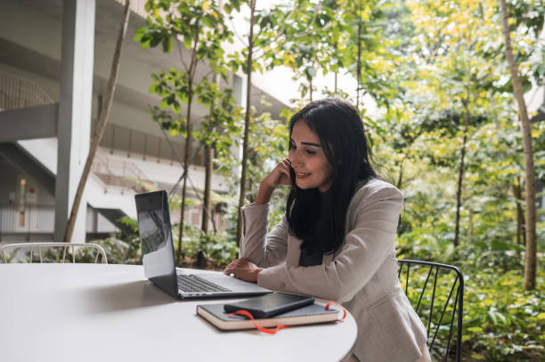 istock Indian woman using laptop computer next to garden 1469019723