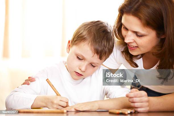 Mother Helping With Homework To Her Son Stock Photo - Download Image Now - Activity, Adult, Beautiful People