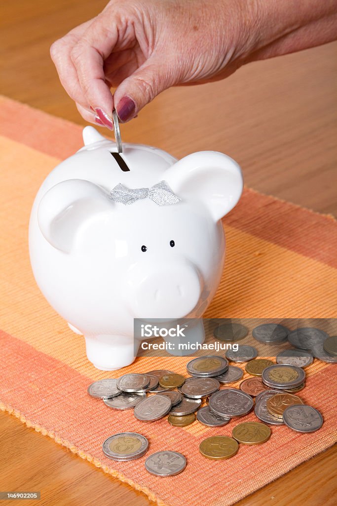 Colocar moeda em piggy bank - Foto de stock de Moeda Sul-africana royalty-free