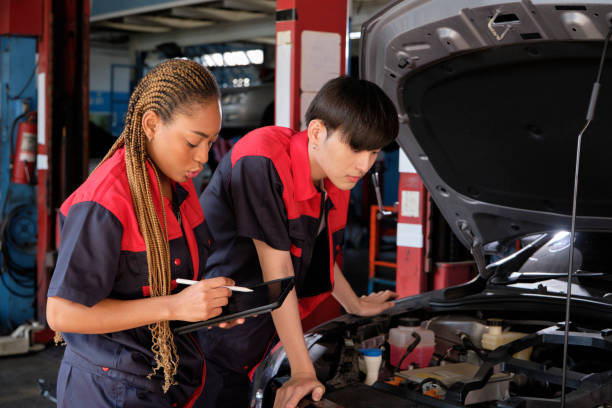 istock Two automotive mechanical partners check an EV car at a fixing garage. 1469028801
