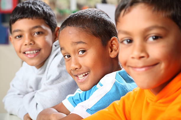 istock Row of three smiling young school boys sitting in class 146903229